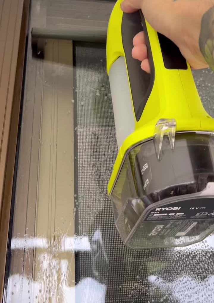 Cleaning a glass sliding door with a cordless window vacuum